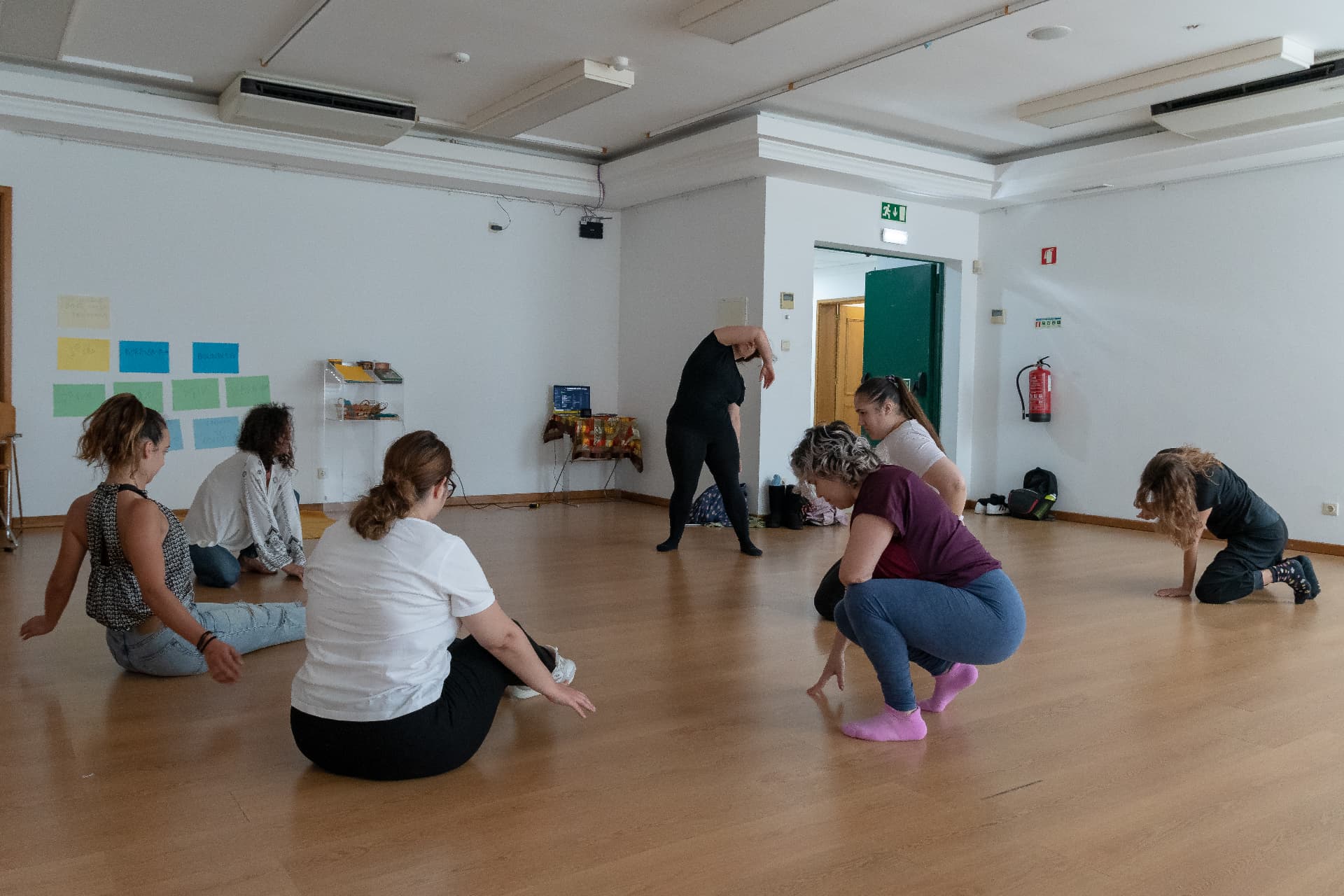 Participantes em exercício de corpo no chão da sala do workshop na Ribeira Grande