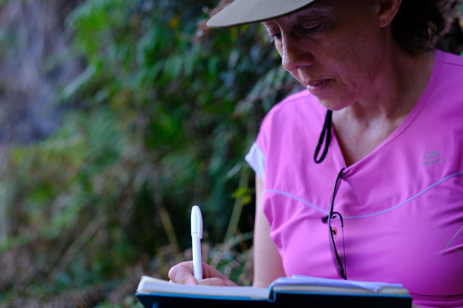Participante a escrever num caderno durante o percurso